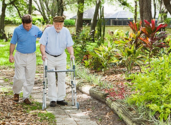 Younger Man Walking With Older Man Along A Path