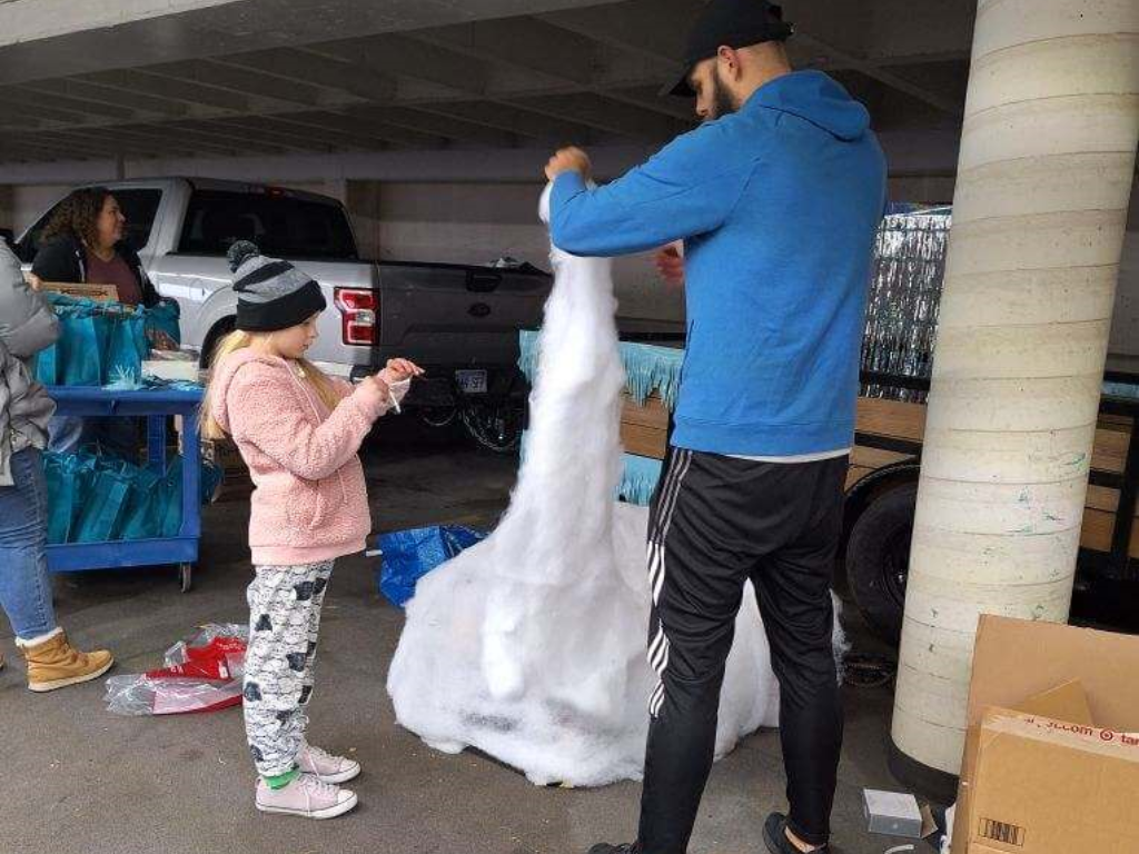 Father And Child Pulling Apart Snow To Build Fake Igloo