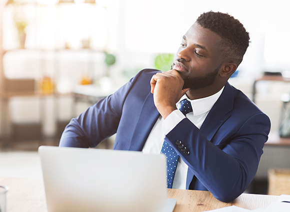 man in thought at laptop