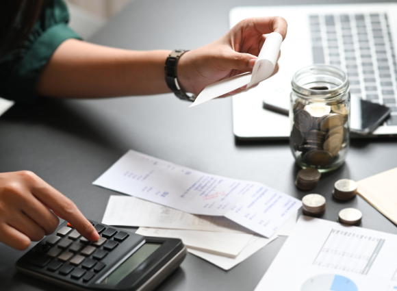 Photo Of A Person Entering Receipt Amounts Into A Calculator