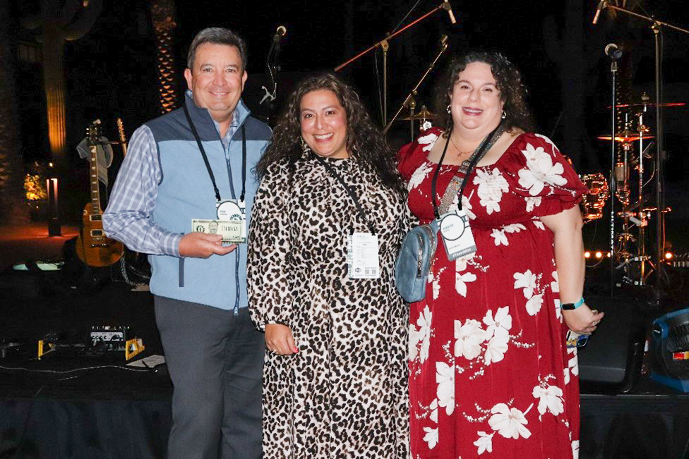 Tim Shmidl holds the winning Tim Buck while posing with the winner, Maria Acosta. Next to Maria is Martie Rison, Mize CPAs Marketing and Communications Manager